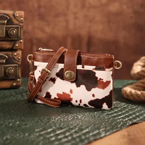 Vintage Western style cow print crossbody clutch bag with gold-tone hardware detail