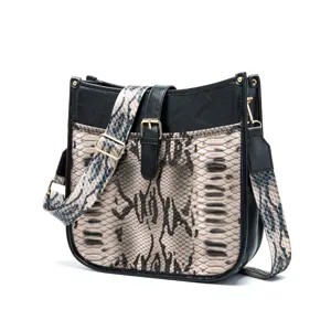 Detailed shot of a Western style snakeskin crossbody bag with black faux leather accents.