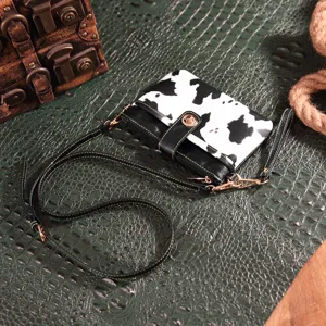 Detailed view of the Western Bohemian cow print crossbody bag with a gold clasp.