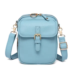 Detalle frontal de un pequeño bolso bandolera de cuero azul claro con herrajes dorados