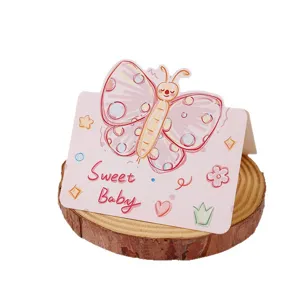 Mignonne carte de vœux papillon rose avec texte Sweet Baby sur une tranche de bois naturel