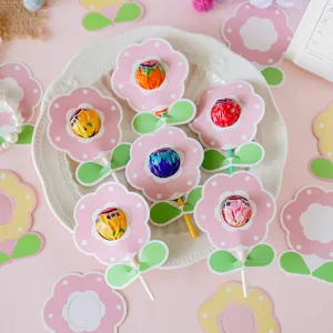 Cute decorative flower-shaped paper cards for lollipops in a soft pastel pink theme