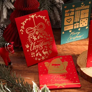 Exquisite goldfolierte Weihnachtskarten auf einem rustikalen Holztisch dekoriert