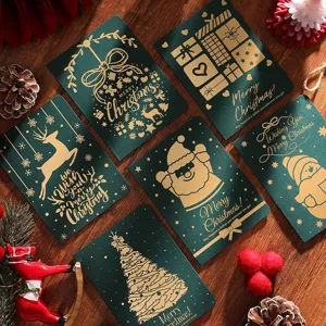 Gros plan de cartes de vœux de Noël vintage en feuille d'or avec rennes et Père Noël festifs