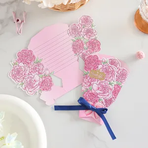 Dettaglio cartolina bouquet 3D con garofani rosa, fiocco blu scuro e scritte in lamina dorata