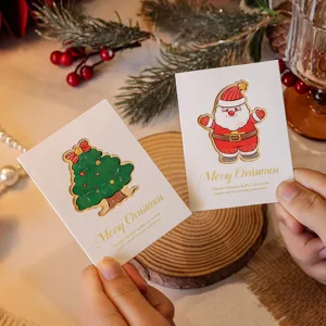 Close-up of decorative hollow-out Christmas cards featuring Santa Claus and tree designs