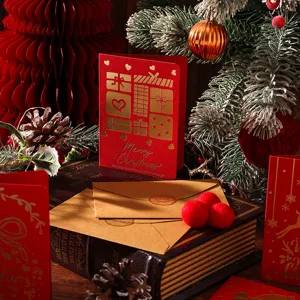 Nahaufnahme einer roten Vintage-Weihnachtskarte mit Goldfolie und Kraftumschlag