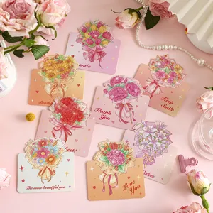 Vista macro de tarjetas de felicitación con ramos de flores y texto dorado