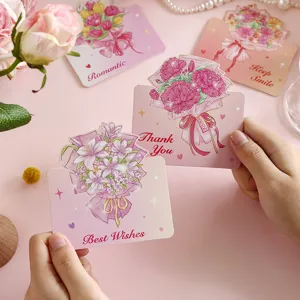 Detalle de tarjetas de felicitación plegables con ramos de flores románticos y texto