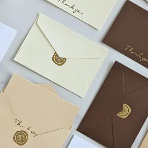 Primo piano di biglietti d'auguri minimalisti con lamina d'oro e sigilli in ceralacca
