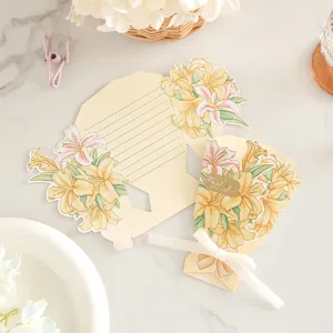 Vista del biglietto d'auguri a bouquet 3D con stampa di gigli e fiocco bianco.