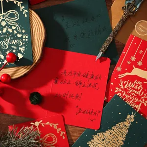 Détail de cartes de Noël vintage avec dorure à l'or et messages manuscrits festifs.