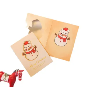 Minimalist hollow-out Christmas greeting card with cute snowman design and gold foil text
