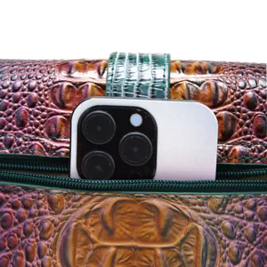 Vista detallada del bolso de cuero vintage con patrón de cocodrilo y móvil para escala