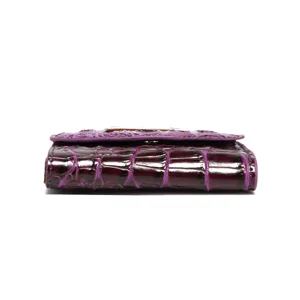Detalle lateral de una cartera triple para mujer en piel con relieve de cocodrilo