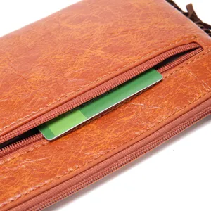 Detalle de cerca de un bolso de mano vintage de cuero marrón con bolsillo con cremallera