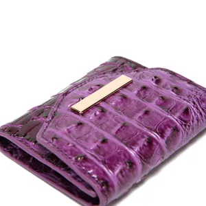 Vista detallada de billetera triple lila con textura de cocodrilo y oro