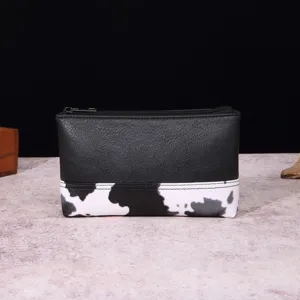 Neceser vintage de cuero sintético con detalle de estampado de vaca negro y blanco