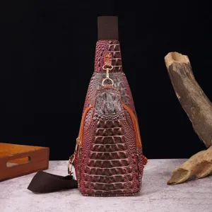 Vista detallada del bolso de pecho burdeos con textura de cocodrilo y herrajes dorados.