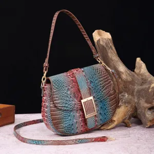 Vista detallada del bolso baguette vintage con patrón de cocodrilo sobre madera.