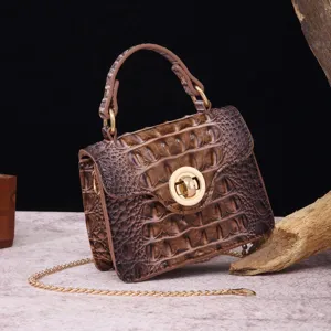 Detail view of vintage brown crocodile embossed leather handbag with golden turn lock