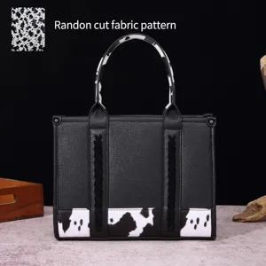 Vista detallada de la tela con estampado de vaca en un bolso de mano western negro