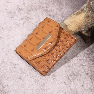 Primer plano de una cartera retro marrón de tres pliegues para mujer con diseño de cocodrilo