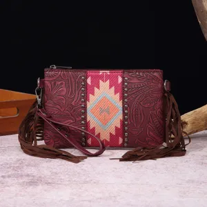 Detalle de cartera de mano de cuero con relieve estilo bohemio y flecos