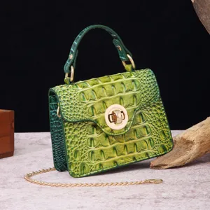 Detail of a green vintage crocodile-patterned mini handbag with gold chain strap