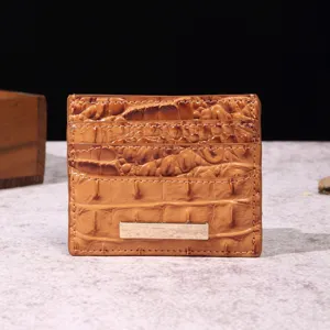 Primo piano di un porta carte in pelle marrone goffrata coccodrillo con placca