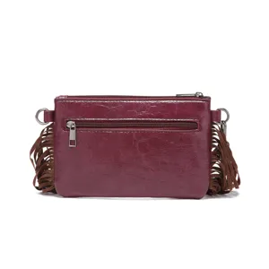 Vista detallada de bolso de mano de cuero burdeos con flecos marrones estilo bohemio
