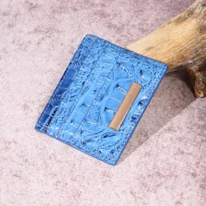 Vista ravvicinata di un porta carte in pelle blu con trama a coccodrillo e barra dorata
