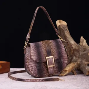 Bolso bandolera vintage con relieve de cocodrilo y herrajes dorados sobre madera