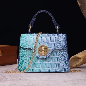 Macro view showing the vibrant blue-green gradient crocodile texture and gold hardware