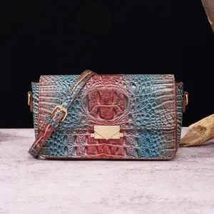 Detalle de bolso bandolera de mujer en piel con relieve de cocodrilo retro multicolor