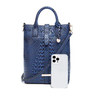 Bolso de mano azul vintage grabado cocodrilo con teléfono como referencia de tamaño