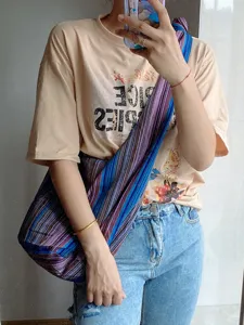 Detalle del bolso bandolera de lona con rayas aztecas de colores en uso diario