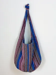 Bolso hobo vintage de algodón y lino con rayas aztecas colgado en una pared blanca
