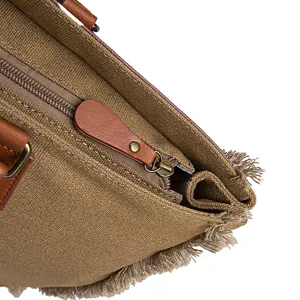 Close-up of metal zipper and leather puller on brown vintage canvas tote bag with fringe