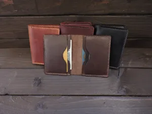 Detail shot of multiple vintage crazy horse leather card holders on wood background