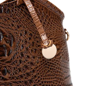 Detalle de la textura de cuero marrón con grabado de cocodrilo en bolso retro para mujer