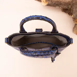 Vista interior detallada de un bolso azul vintage con textura de cocodrilo en relieve