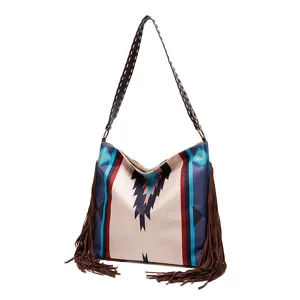 Close-up view of bohemian patterned canvas tote bag featuring long brown fringe tassels
