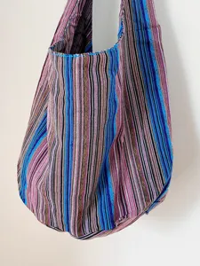 Detalle del bolso de hombro de lona tejida de estilo azteca con rayas de colores.