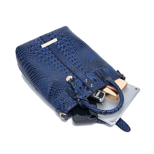 Vista detallada de bolso azul con grabado de cocodrilo mostrando gran capacidad para objetos.