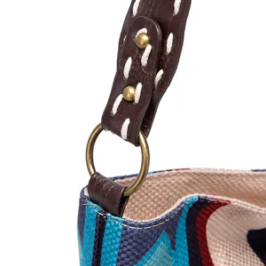 Detail of retro woven tote bag strap featuring a vintage metal ring and bronze rivets