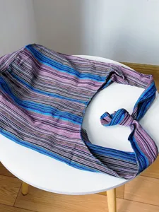 Vista superior de un bolso hobo de lona azteca retro en una mesa blanca minimalista