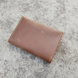 Detailed view of a vintage brown crazy horse leather card holder with hand-stitched edges