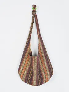 Detalle del patrón azteca vintage en un bolso de hombro tipo hobo de algodón y lino