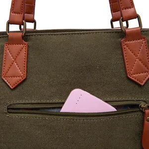 Close-up detail of the functional side zipper pocket on a vintage green canvas tote bag